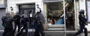 Malgré les manifestations dans sa rue, ce coiffeur, professionnel jusqu'au bout, continue à coiffer son client !